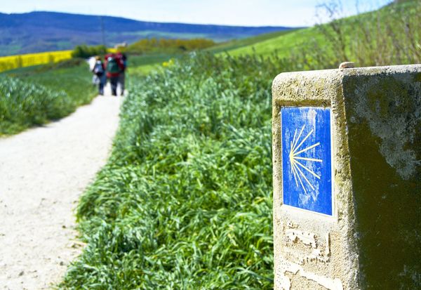 Camino-de-Santiago-Marker-with-Pilgrims-in-the-Distance