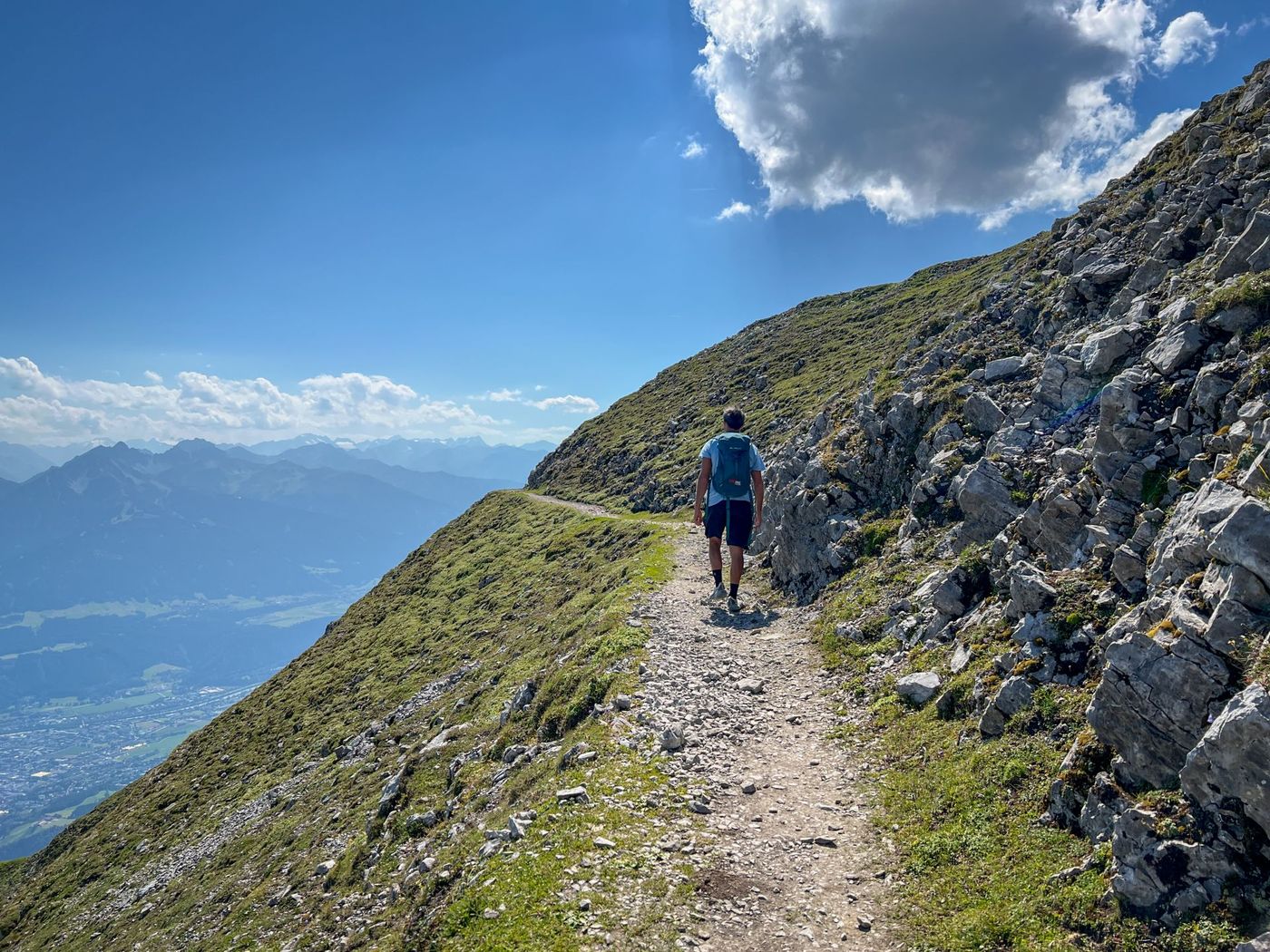 Hiker on a high-altitude trail offering a sprawling panoramic view of the Inn Valley - supplied by Eurohike
