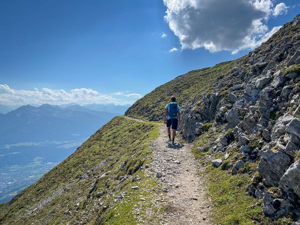 Hiker on a high-altitude trail offering a sprawling panoramic view of the Inn Valley - supplied by Eurohike