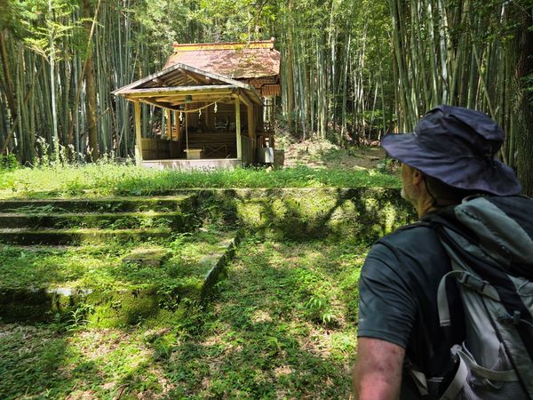 Hiker staring at the wooden shrine