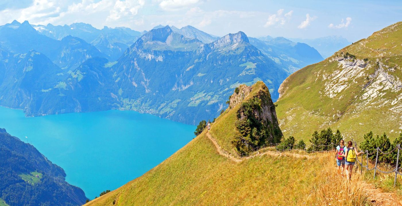 Hikers following a scenic ridge trail between Klingenstock and Fronalpstock near Stoos, Switzerland