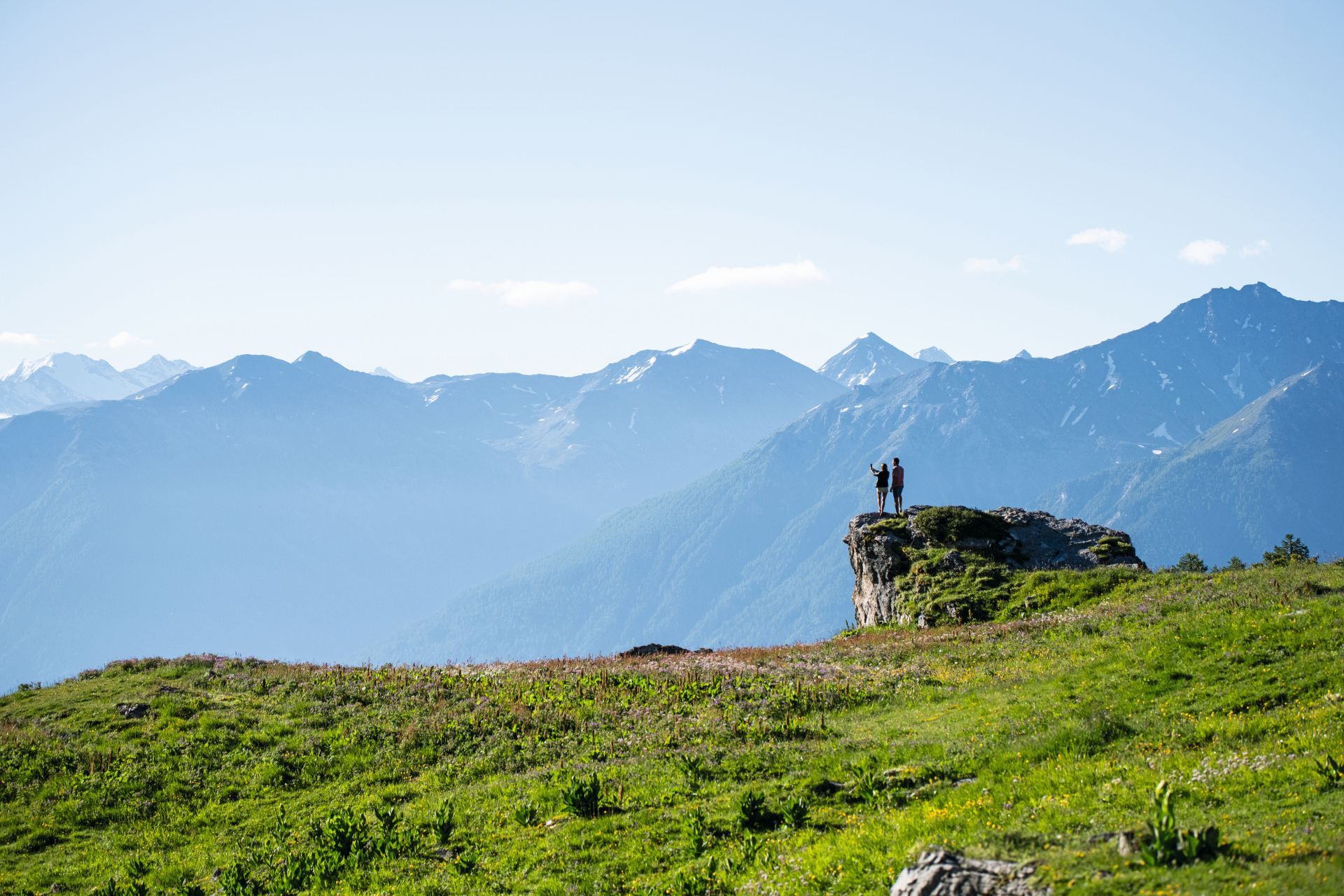 Hikers on a lush green meadow along the Wildstrubel circuit trail in the Valais region of Switzerland-supplied by Eurotrek
