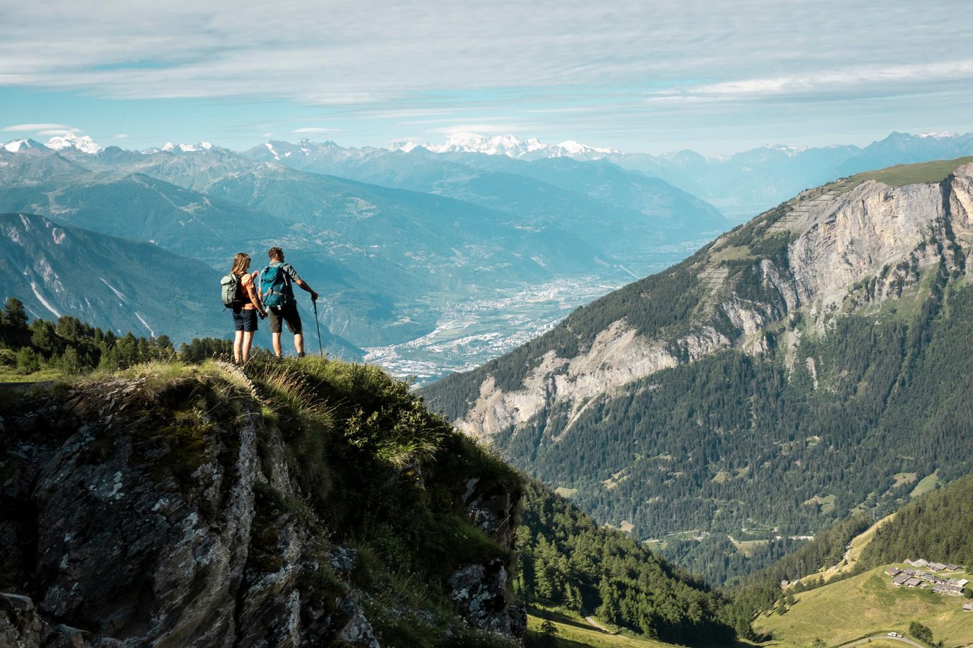 Hikers standing on a clifftop, looking out Pennine Alps near Leukerbad in the Valais canton of Switzerland-supplied by Eurotrek