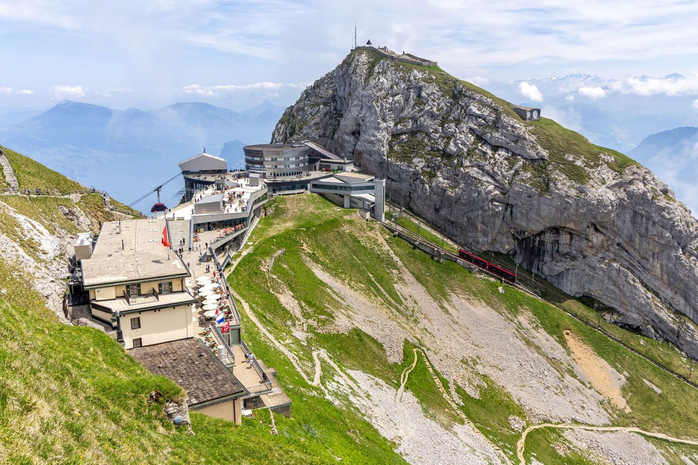 Mount Pilatus Lucerne, Switzerland, with a red cogwheel train visible climbing along the rugged mountain face..
