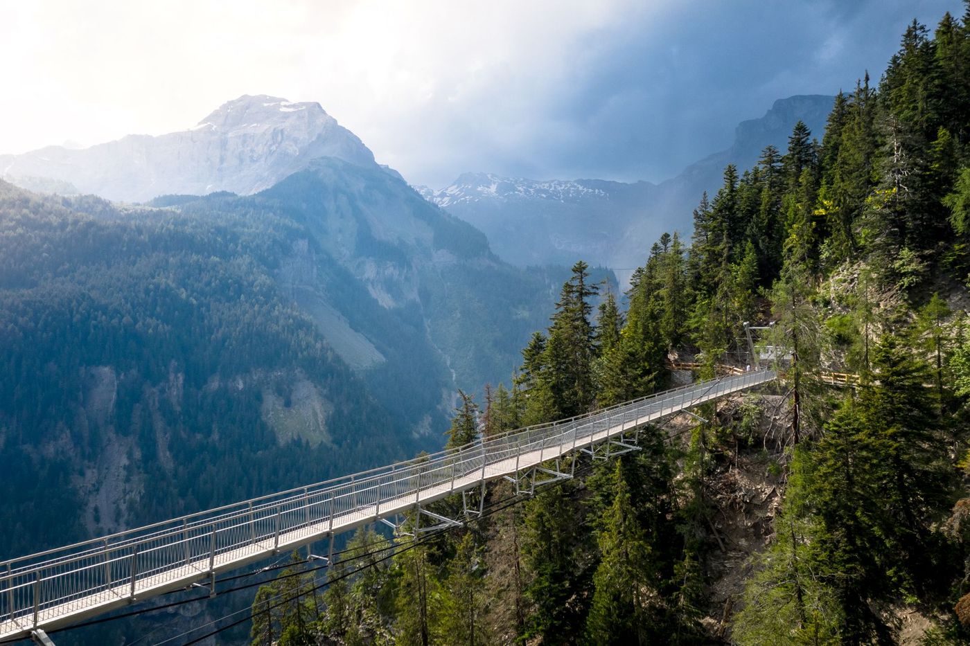Pedestrian suspension bridge in a forested gorge along the Bisse du Ro hiking trail near Crans-Montana, Switzerland- supplied by Eurotrek