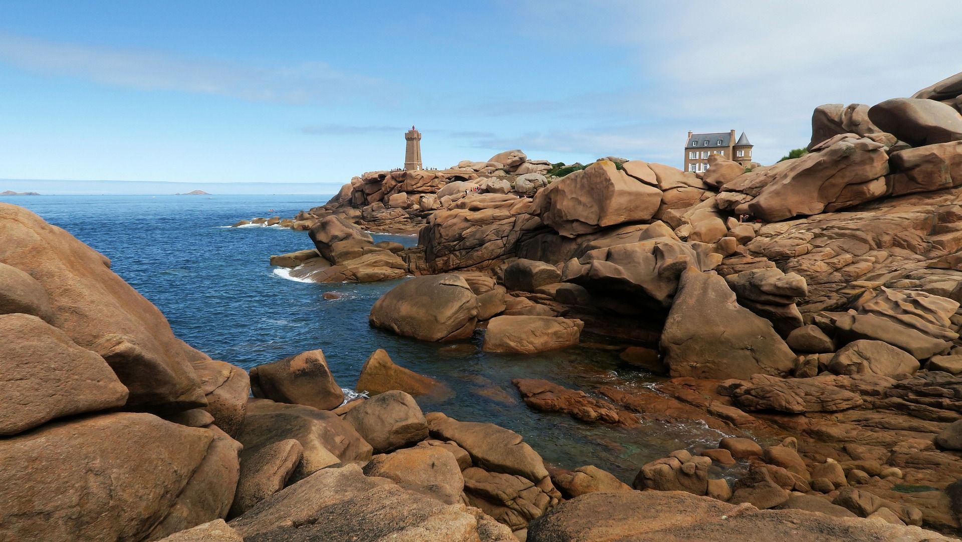 Pink granite boulders with a view of the Mean Ruz lighthouse Ploumanac'h. Brittany France